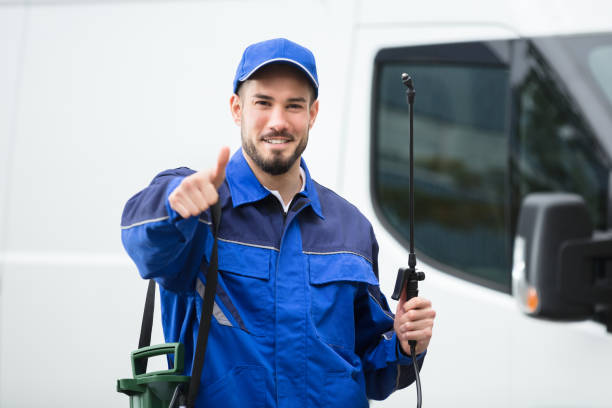 portrait of a smiling male pest control worker standing in front of vehicle